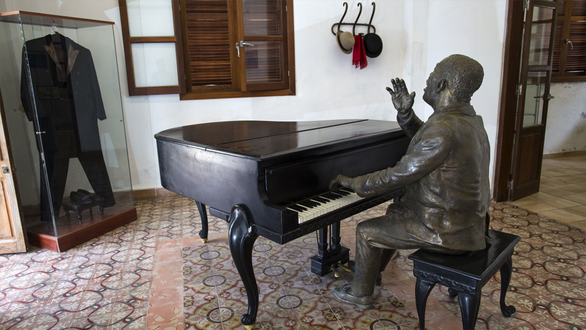 Bronze statue of Bola de Nieve playing the piano in his old house in Regla