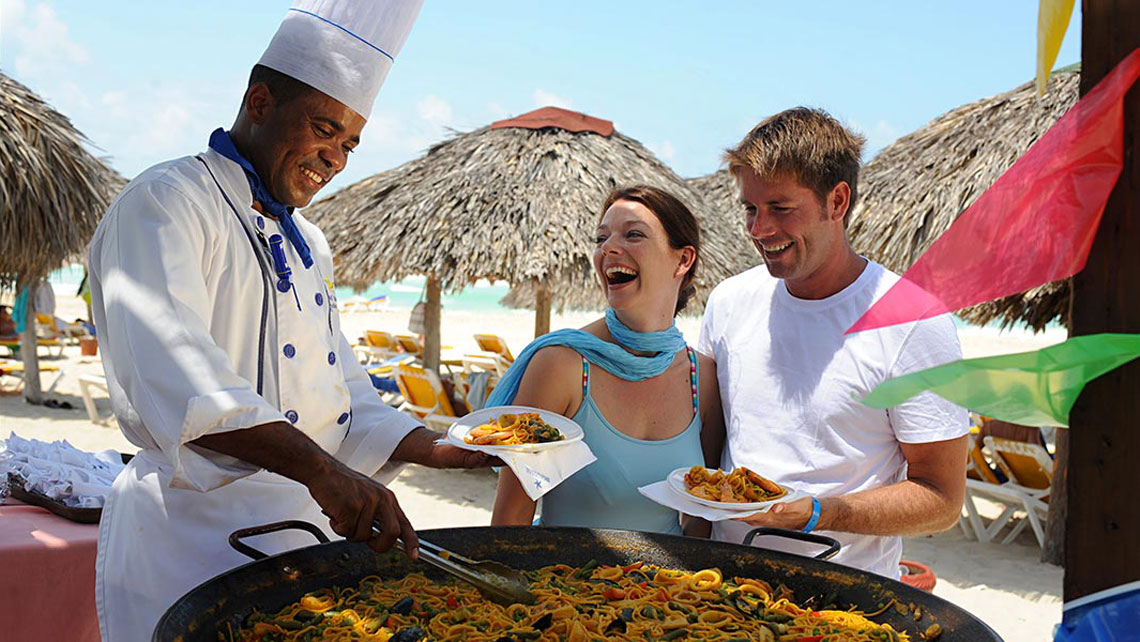 Tourists and a member of a hotel staff laughing