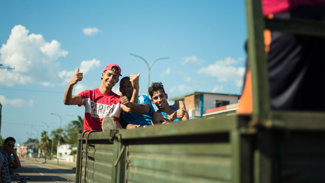 Young men saying hello from the back of a truck