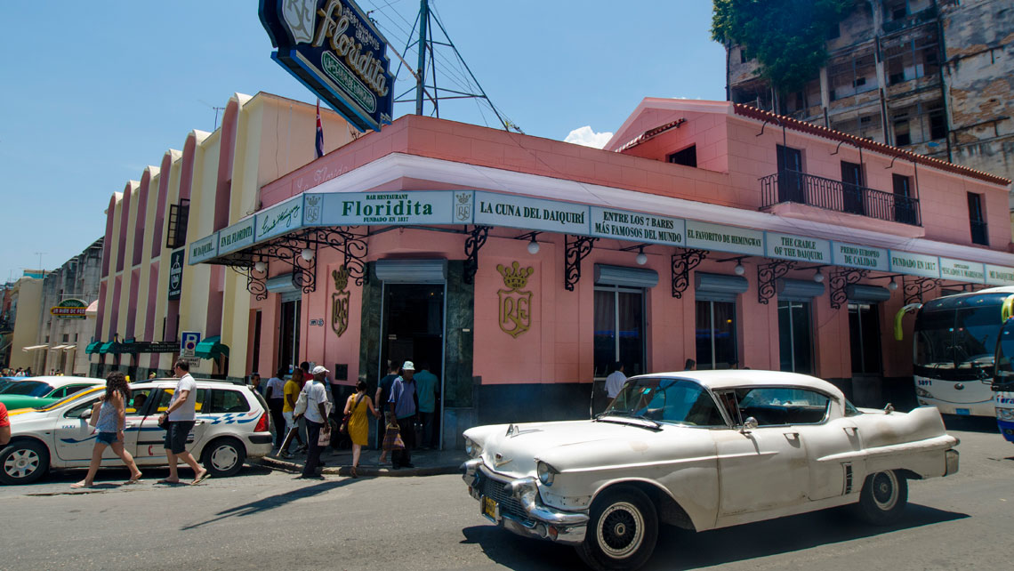 Vintage American car taxi passing in front of El Floridita Bar(a Hemingway hangout)