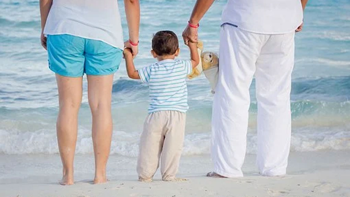 A couple and a child wearing cotton clothes by the sea