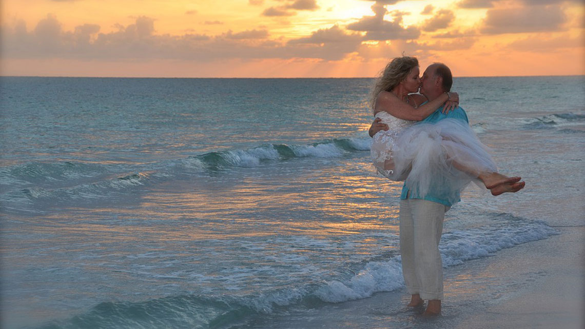 A couple kissing in a beach at sunset