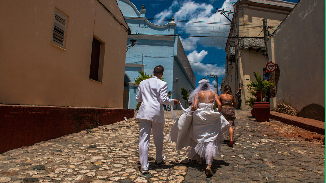 Newlyweds walking on a cobbled street in Sancti Spiritus