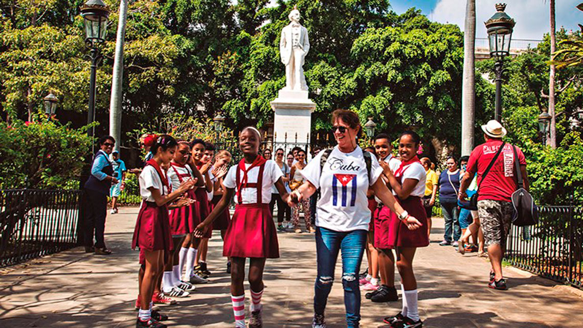 Group of school children walking with their teacher in a park