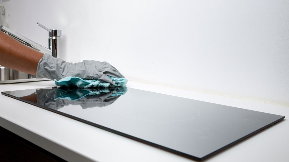 A hand wiping table surfaces