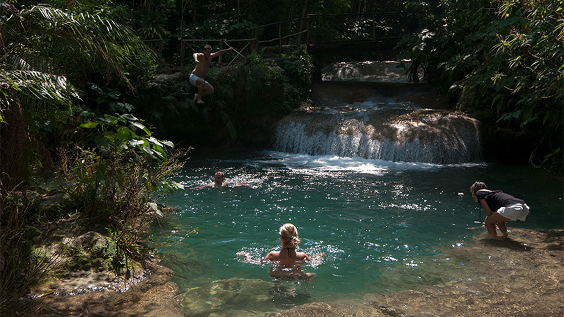 People enjoying in a natural pool with jade-green water in Escambray