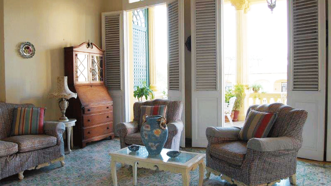 A spacious living room with open doors in a casa particular