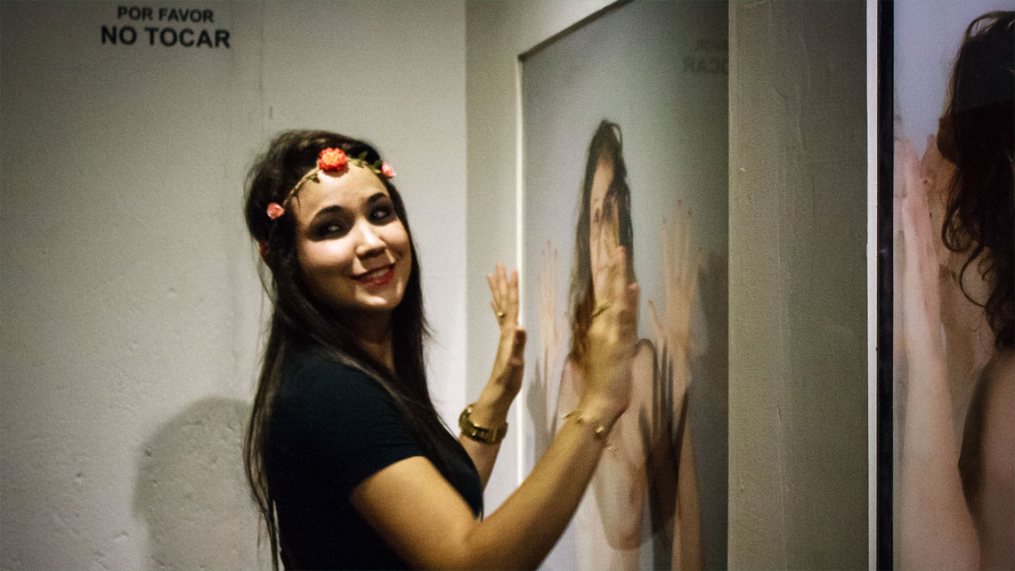 A young woman posing for a photo in front of an artwork in Cuban Art Factory