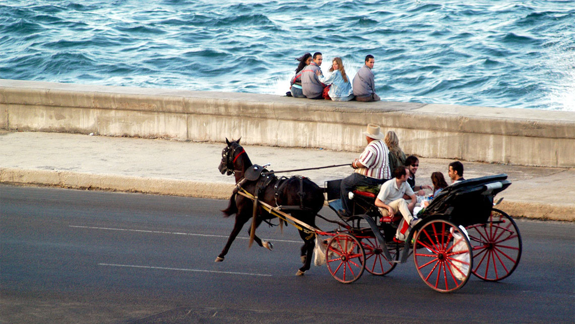 A horse-drawn carriage riding along El Malecon