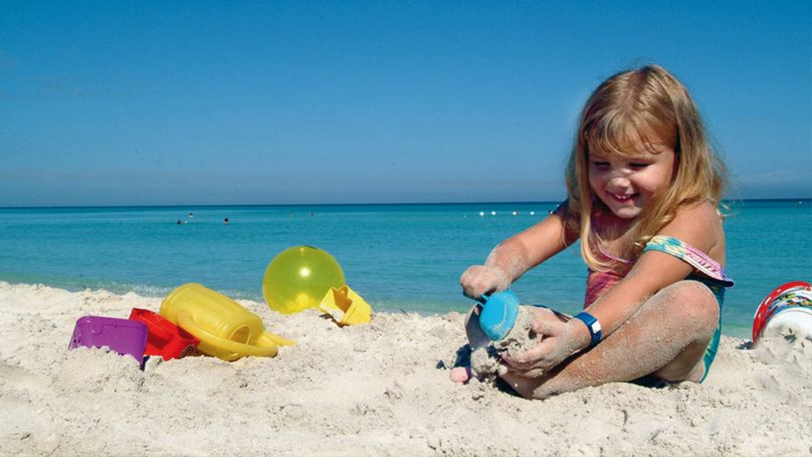 Girl playing with sand in the beach