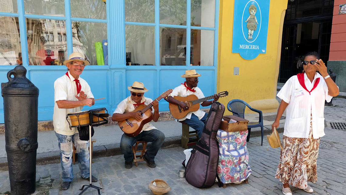 A group of musics wearing traditional clothes playing Cuban music on a street of Havana