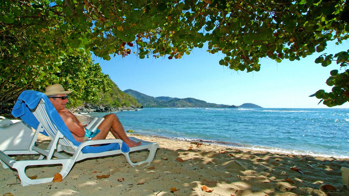 A man reading a book at the beach