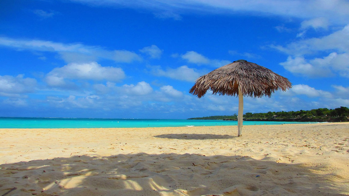 Rustic umbrella at the beach against clear blue sky