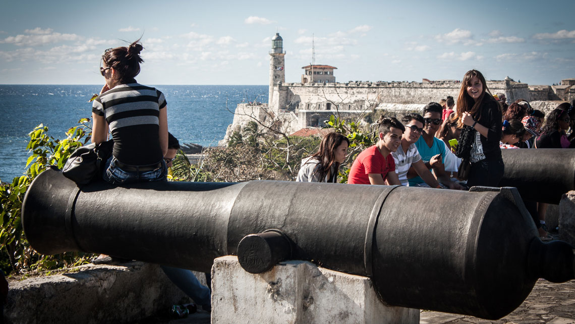 People seating a the walls of La Cabaña just at the entrance of Havana Bay