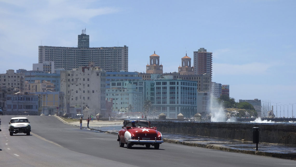Vintage cars driving along Malecon in Havana