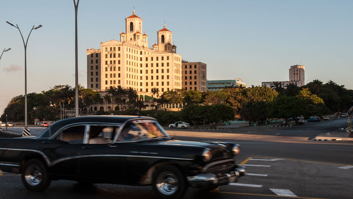Old American car cruising on the Malecon Avenue near Nacional de Cuba Hotel