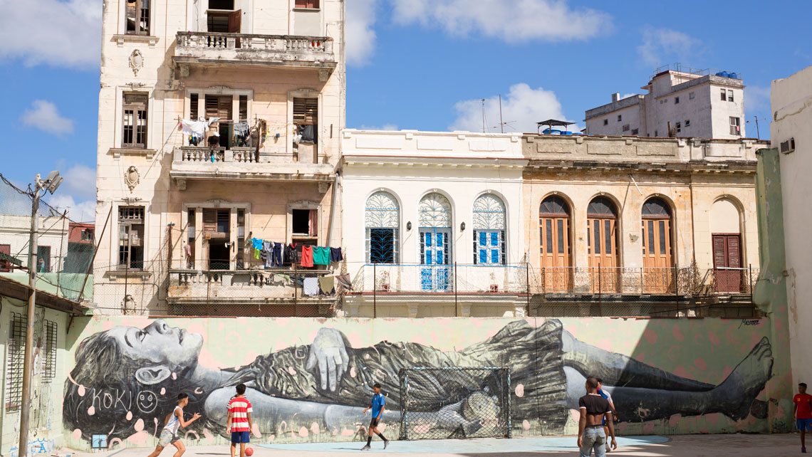 Children play next to a graffiti in Havana, Cuba