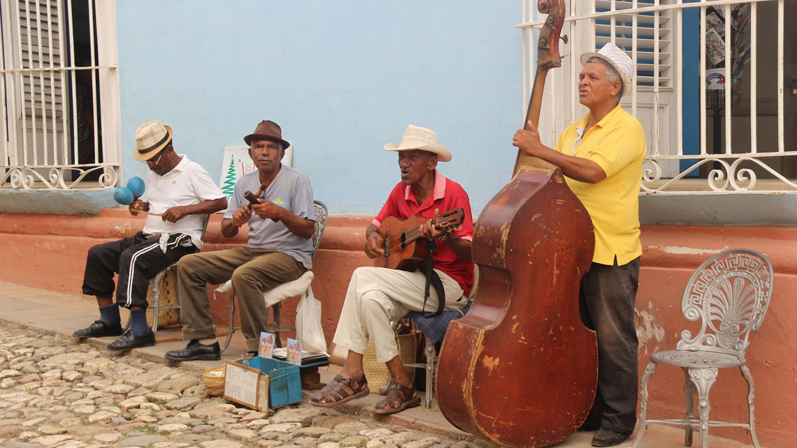 Traditional Cuban street musicians playing songs in the streets of Trinidad with traditional acoustic instruments.