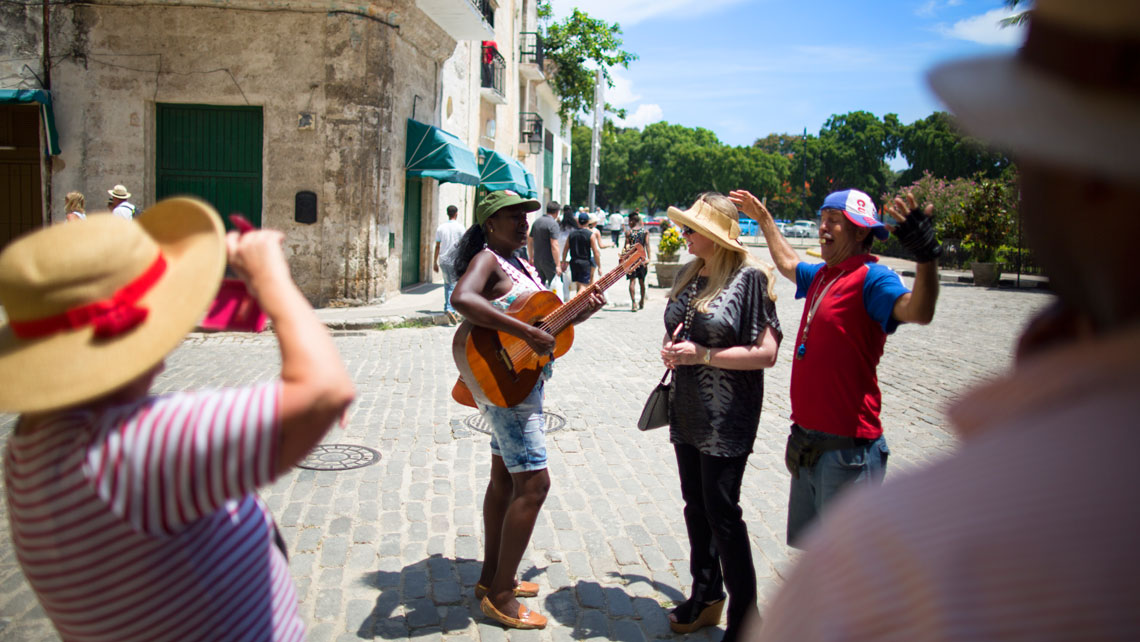 Locals entertaining a tourist woman in Havana