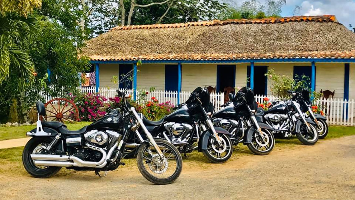 La Poderosa's motorcycles parked outside traditional farmer's house in Vinales Valley